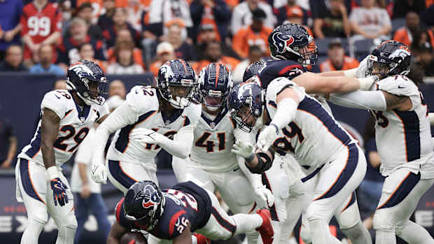 Houston Texans running back Devin Singletary (26) is tackled by Denver Broncos defensive end Zach Allen (99) and teammates for a loss in the second half at NRG Stadium.